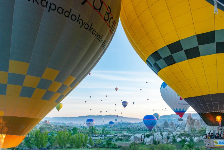 many large balloons are being flown over a town