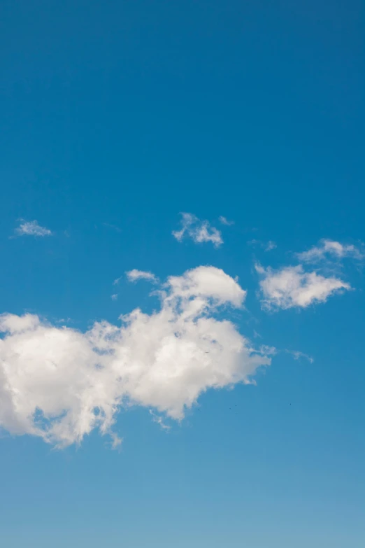 a plane in a clear blue sky with a cloud