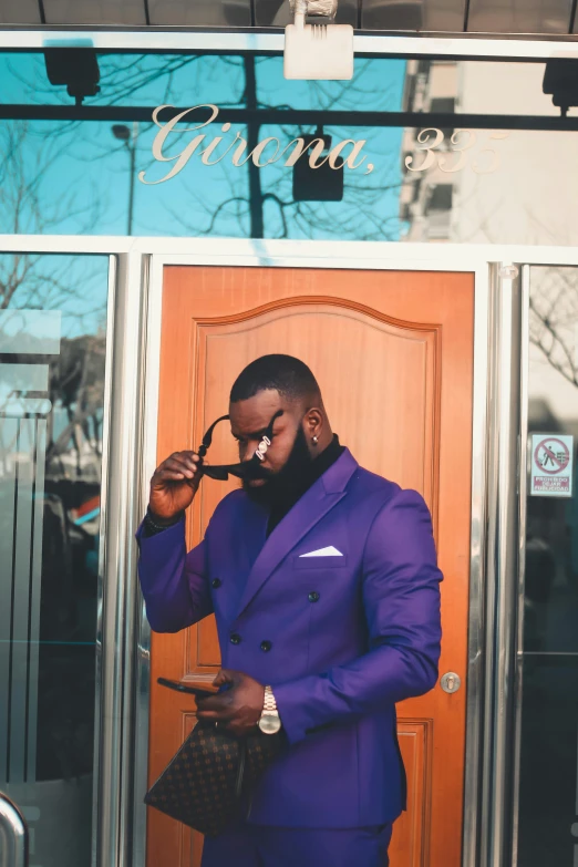 a man wearing a purple suit is smoking a cigarette