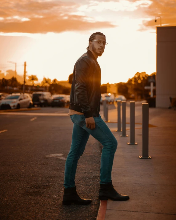 a man on a skateboard stands in front of a parking lot