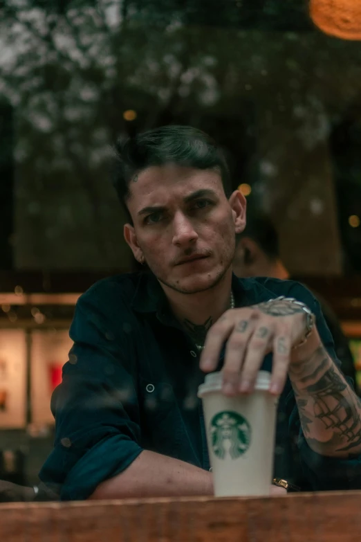 a man is holding a starbucks coffee in one hand