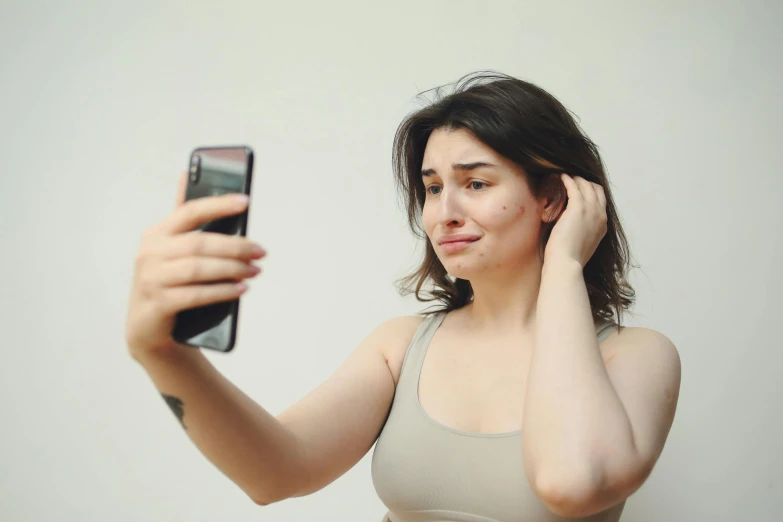 a woman with a phone up to her ear looking down at her