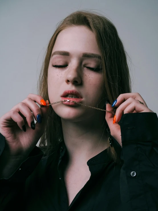 the young woman is holding some beads in her mouth