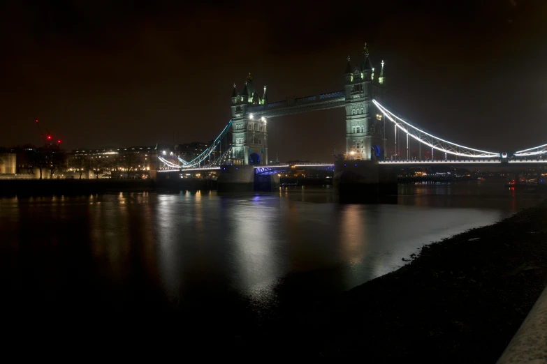 a large bridge is lit up at night