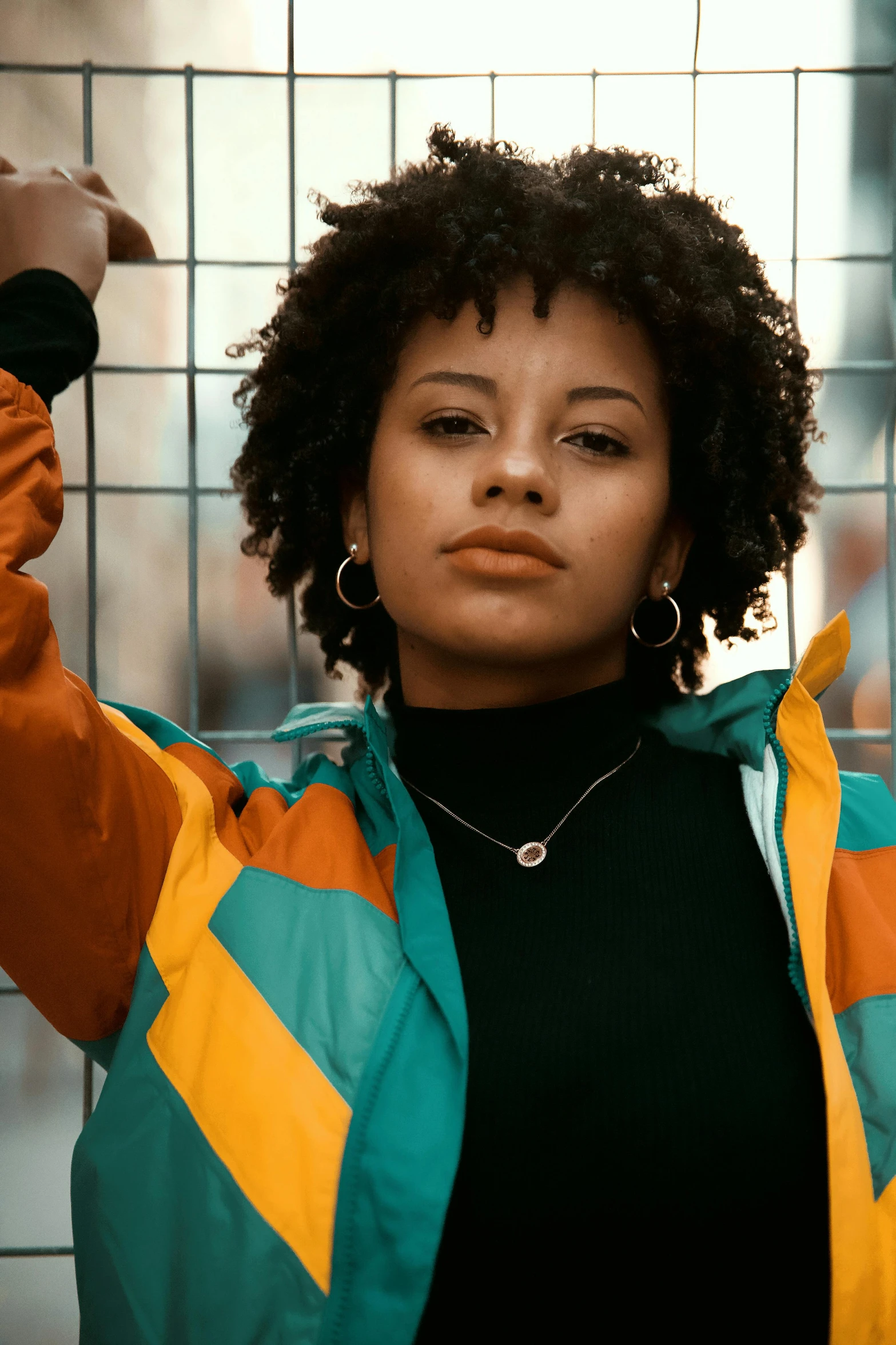 an african american woman stands near a fence