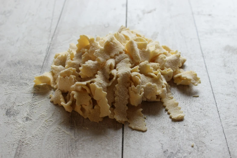 pile of uncooked pasta laying on wooden floor