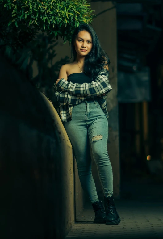 a woman posing in high waisted jeans and plaid top