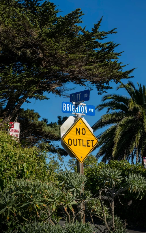 a no outlet street sign with some trees around