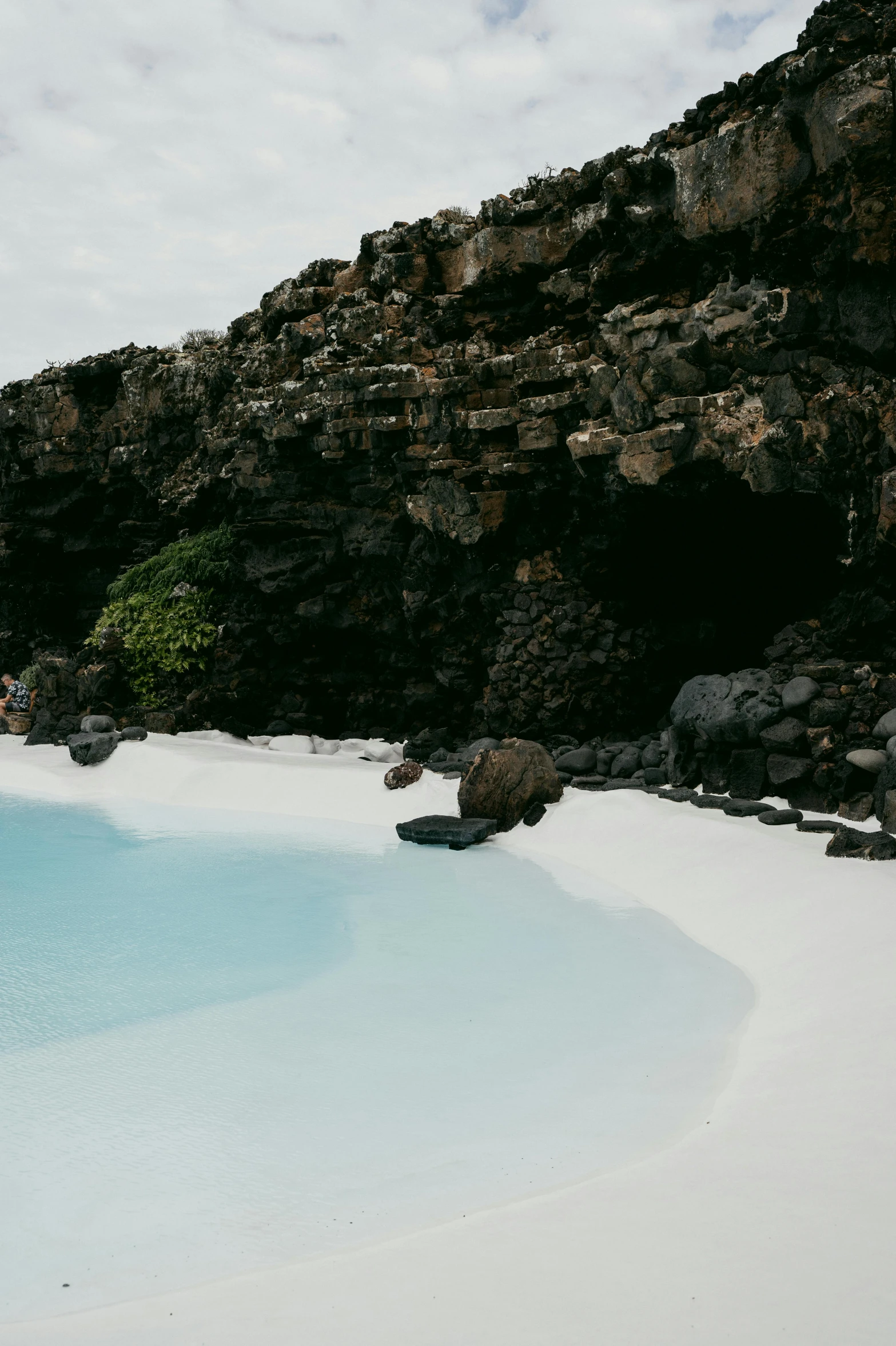 a pool on an island with a bunch of rocks