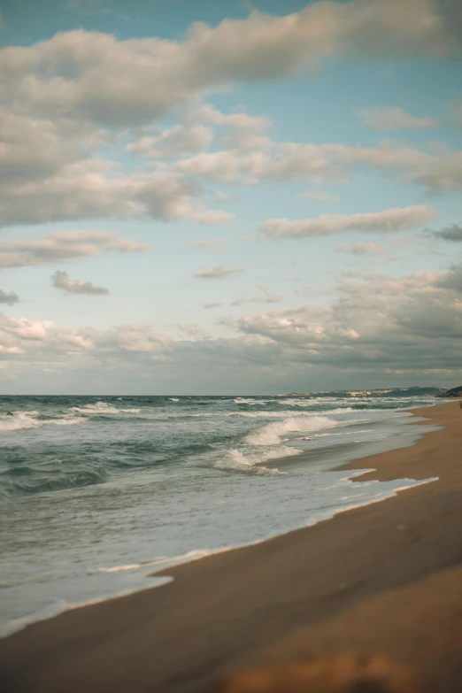 a man walking on the beach with his surf board