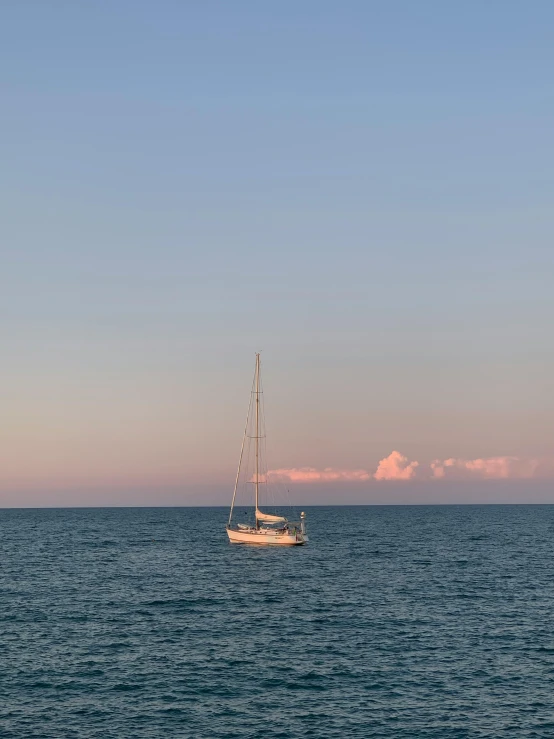 a sailboat in the ocean on a cloudy day