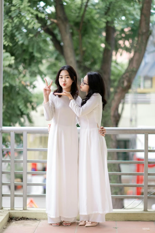 two woman standing together on the sidewalk