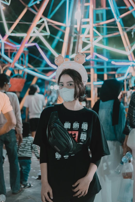 the man is wearing a face mask in front of several carnival rides