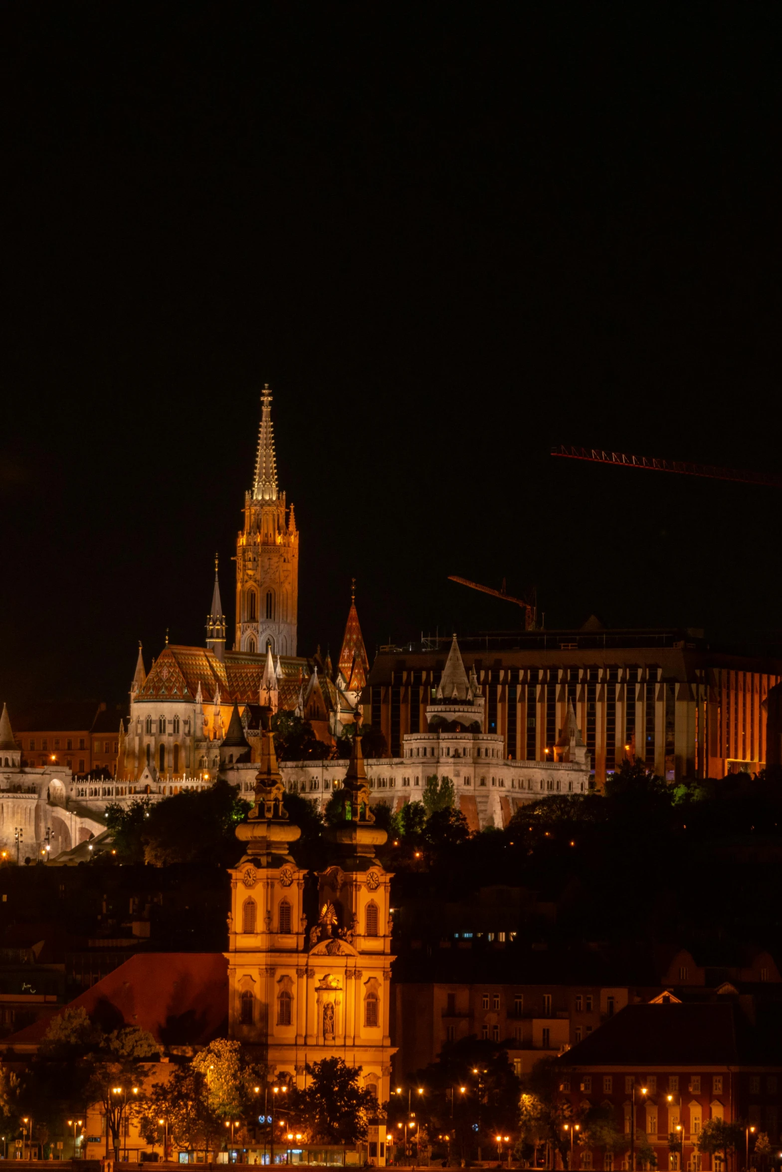 the clock tower is lit up against the city skyline