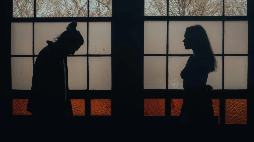 two women are looking out of the windows at each other