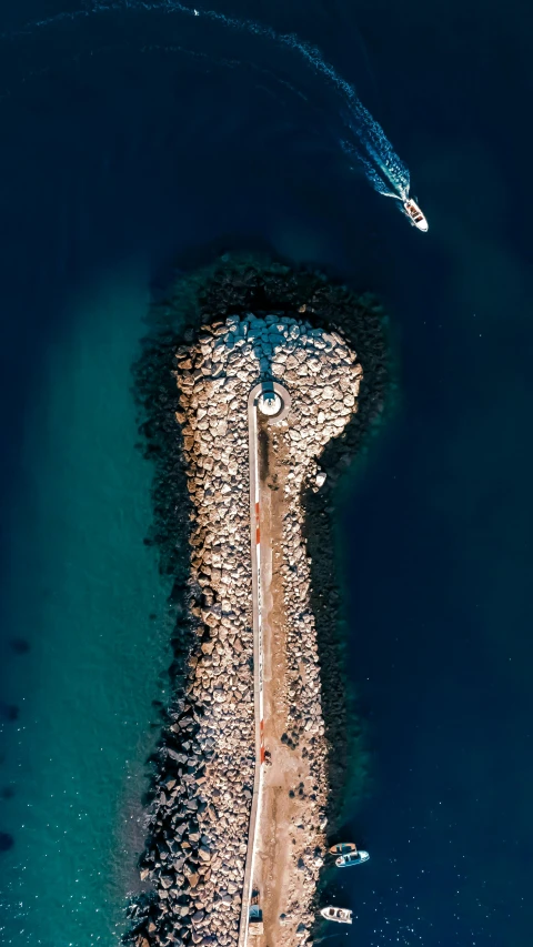 an aerial view of a beach and pier with some water