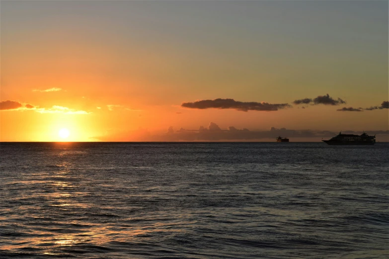 a sunset over the water with small boats