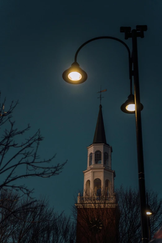 an old church spire lit up in the dark