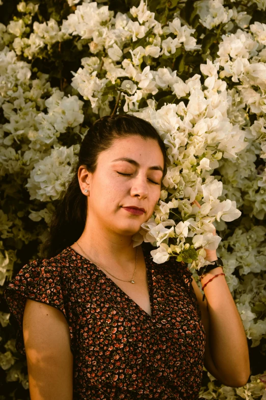 woman with eyes closed while resting her face on her hand