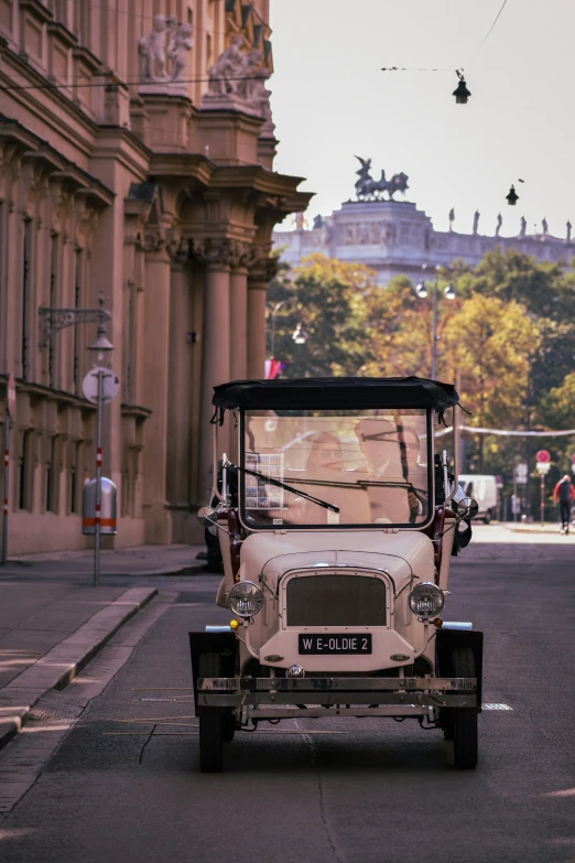 an old fashioned car sits in front of a building