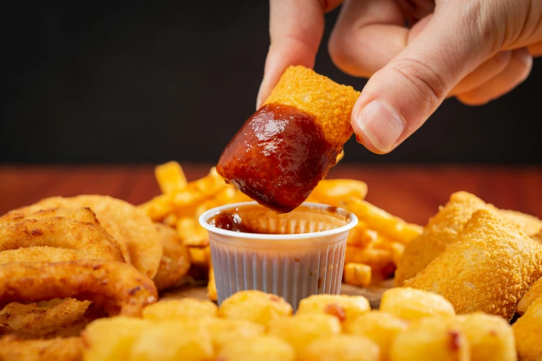 there is a person dipping some food into a little container