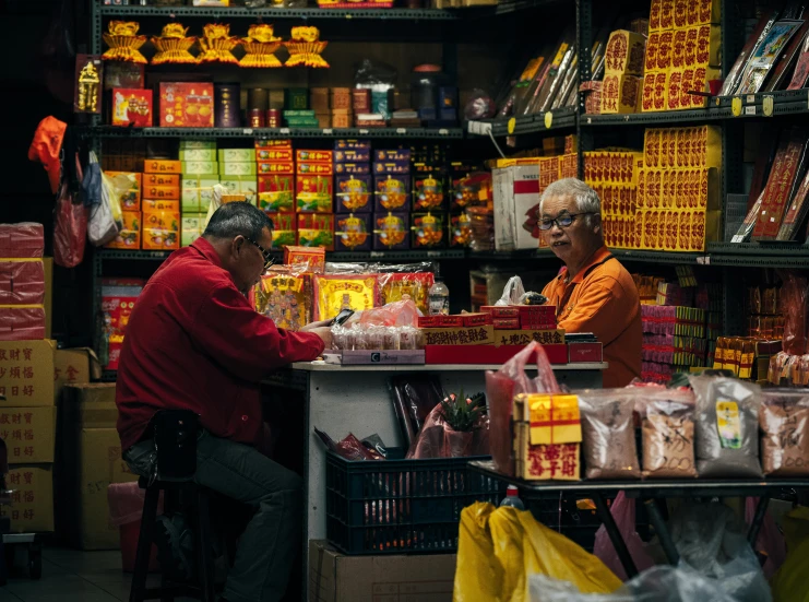 two people are standing in front of a shop with a shelf full of food