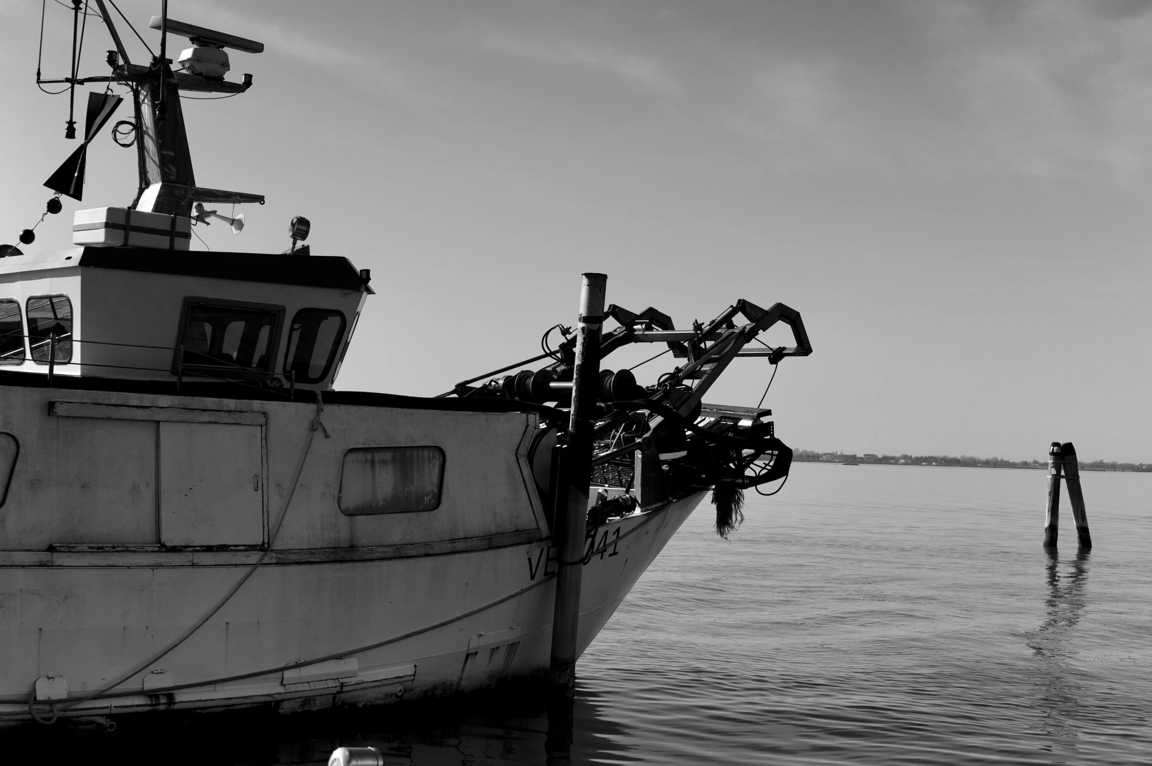 the boat is in the calm water with a crane on it