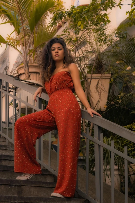 a beautiful woman standing on some stairs near a tree