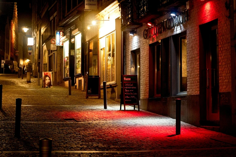 a dark city at night with lights on the side of buildings