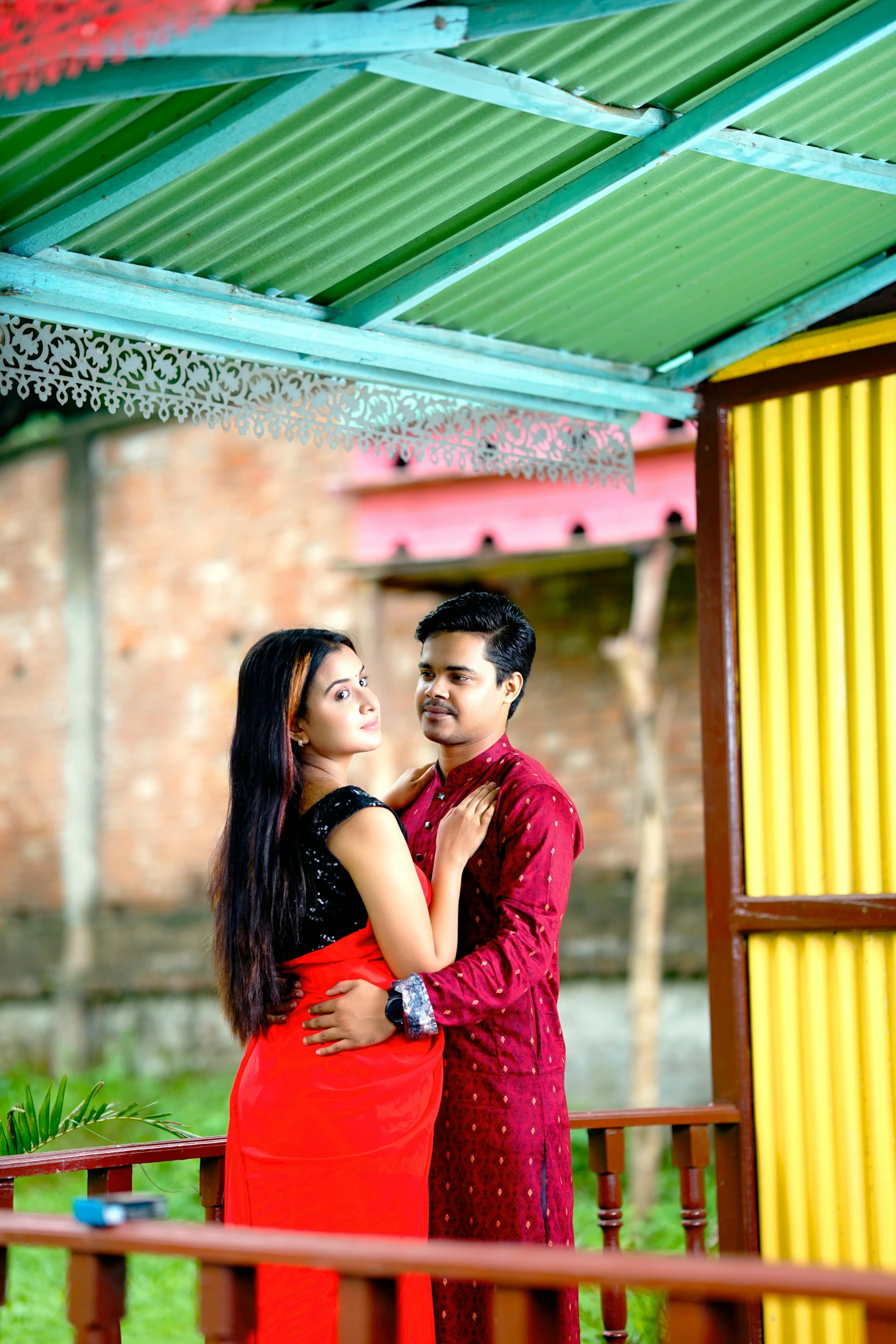 a couple cuddle in an area under a shelter