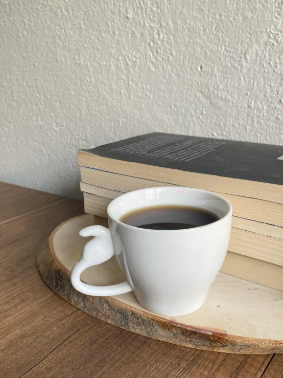 a cup of coffee sits on top of some books