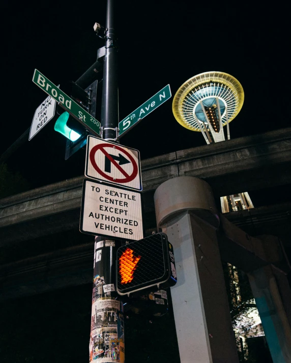 signs directing traffic on a street at night