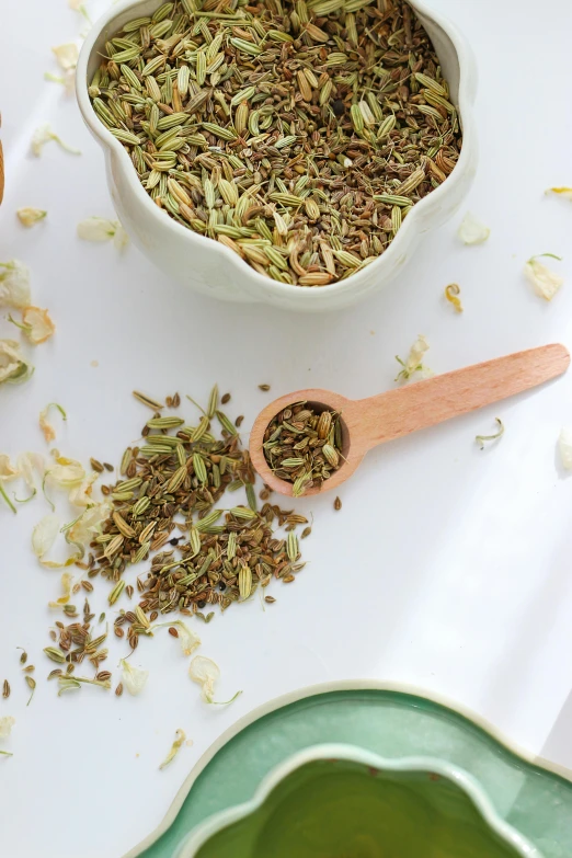 a wooden spoon with some dry herbs in it