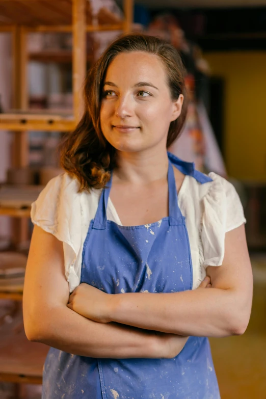 a woman is wearing an apron and a blue shirt