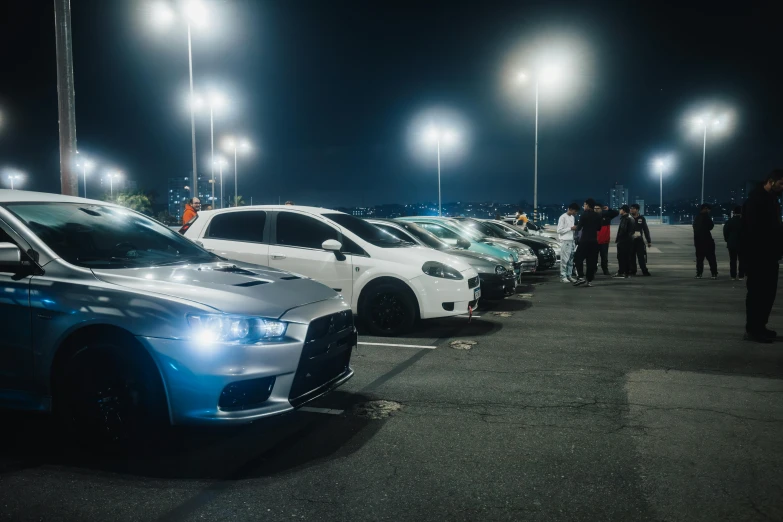 a bunch of cars are parked in the parking lot at night