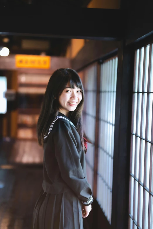 a woman is standing in a tunnel by some windows