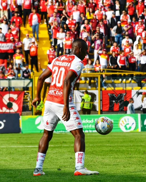 a soccer player in the middle of the field getting ready to kick a ball