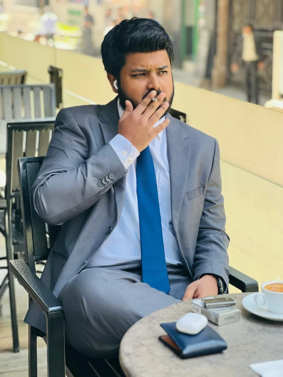 a man sitting in a chair smoking a cigarette