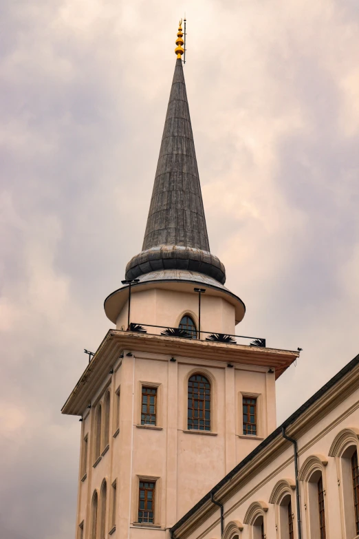 a church steeple with a white building in the background