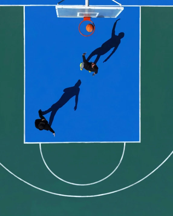 silhouettes of people playing basketball on a court