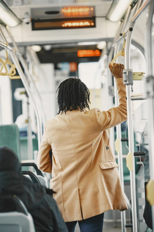 the woman is standing inside of a bus with her hand up