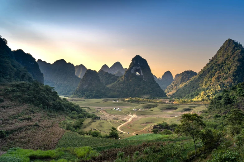 a valley scene with mountains and trees in the distance