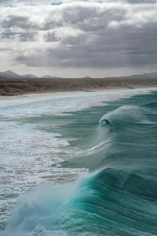 a wave breaking on an ocean near the shoreline