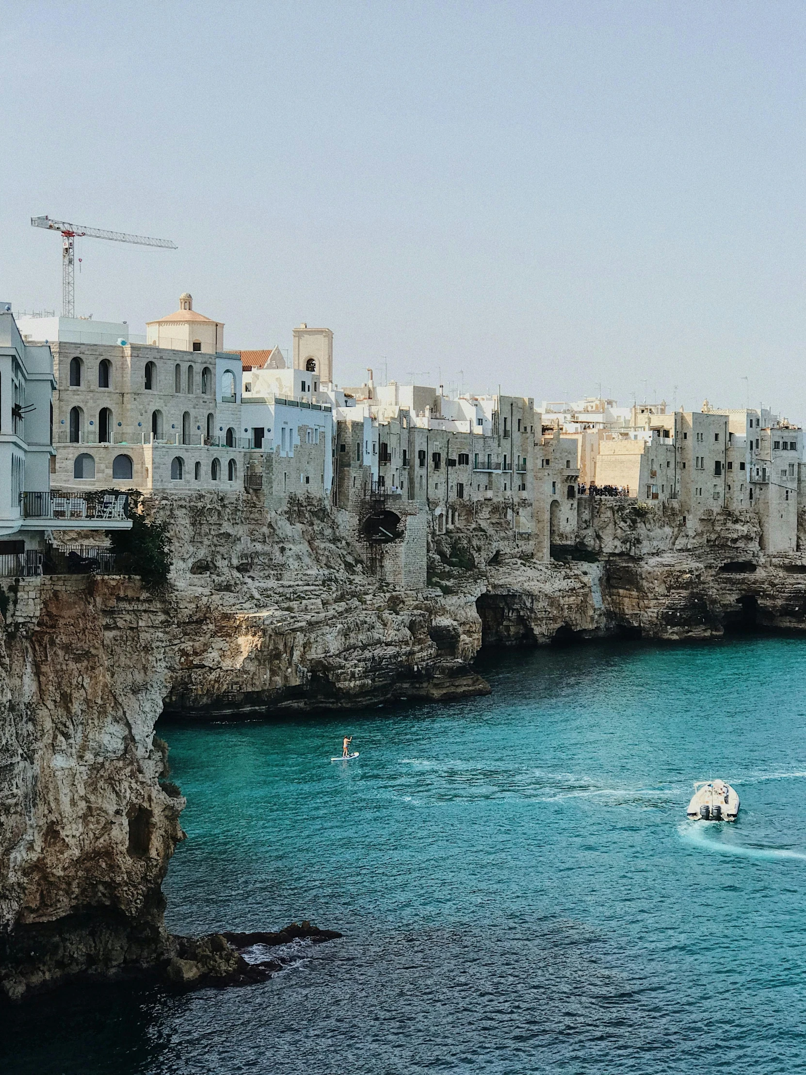 boats are going on the waters near some tall buildings