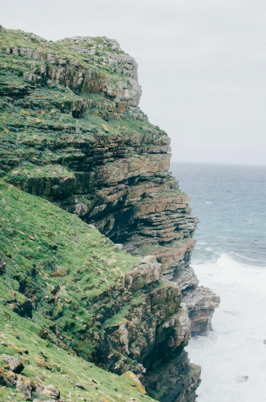 a big cliff next to some sea and some very pretty water