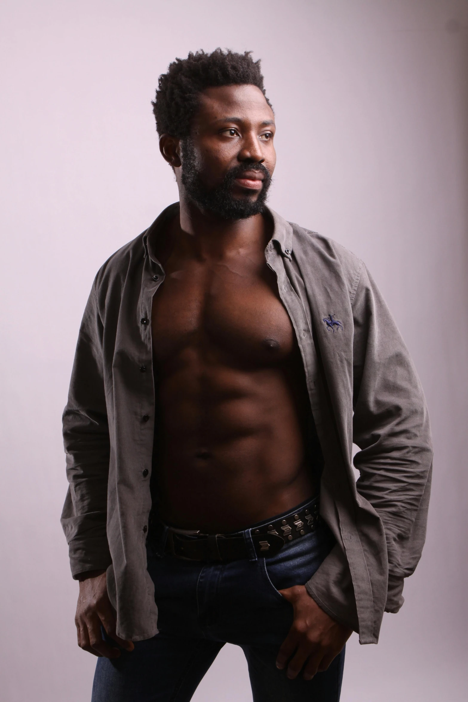 a black man standing in the studio, wearing a shirt