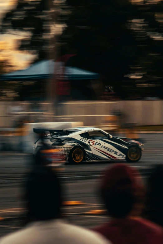 a racing car with white and black stripes is racing down a race track