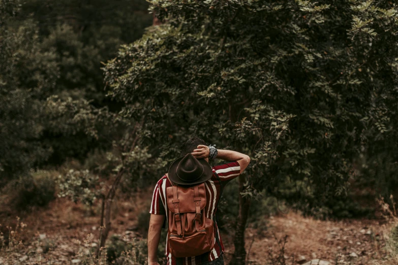 a man standing next to a forest with trees