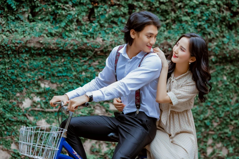 the man rides the woman's bike while holding the girl's hand