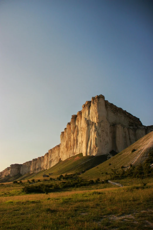 an image of a grassy field with tall cliff